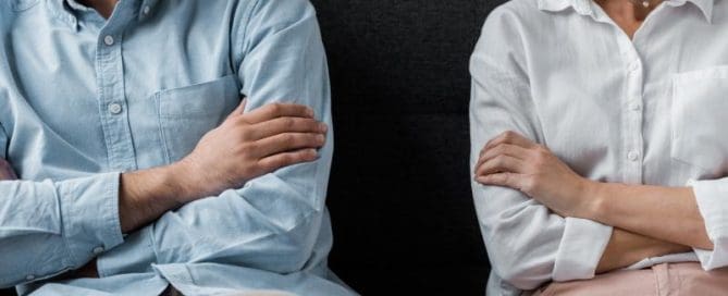 A man and woman sitting on a couch looking at each other