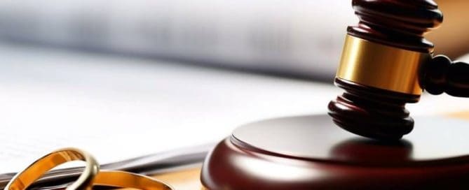 Wedding rings and gavel on a desk.